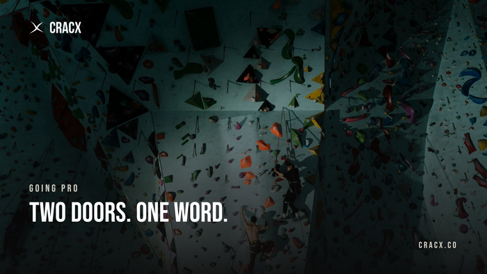 Climbers on ropes high on a tall indoor competition wall, seen from above