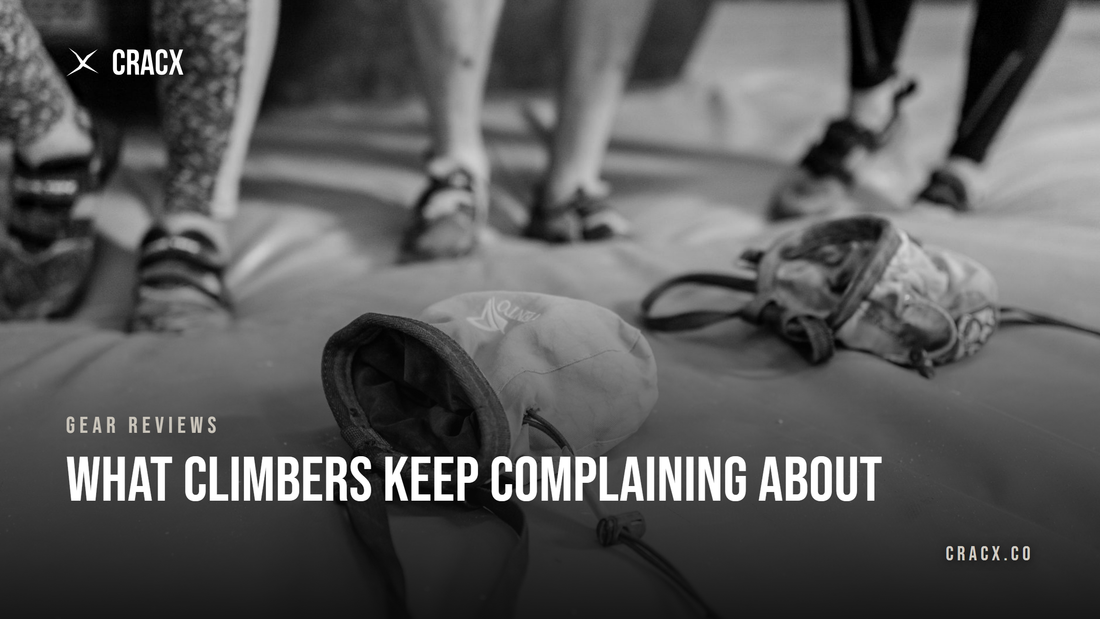 An open chalk bag with its drawstring hanging loose on a bouldering mat, climbers standing behind it