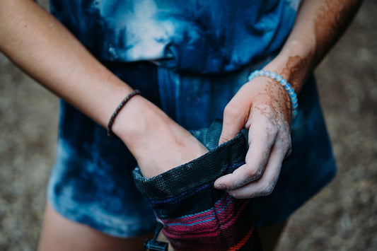 Climber's chalked hands over a chalk bucket — keeping climbing chalk contained