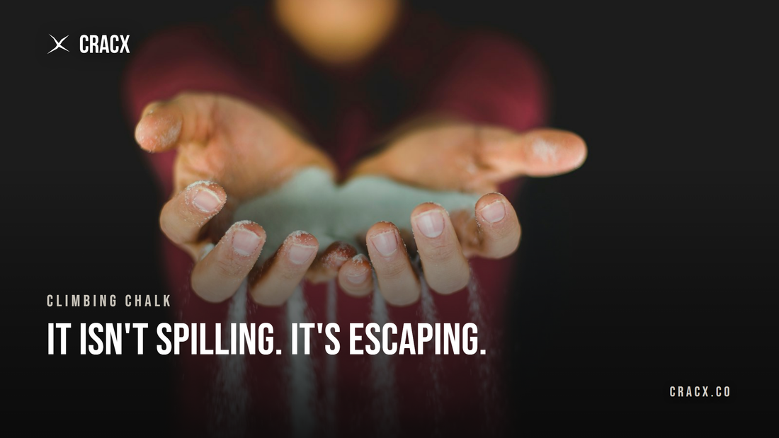 Climbing chalk streaming out between a climber's fingers against a dark background