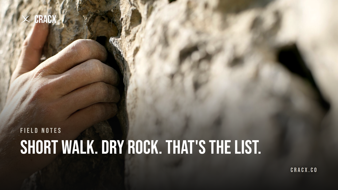 Close-up of a climber's chalky hand gripping a deep pocket on a sunlit outdoor rock face