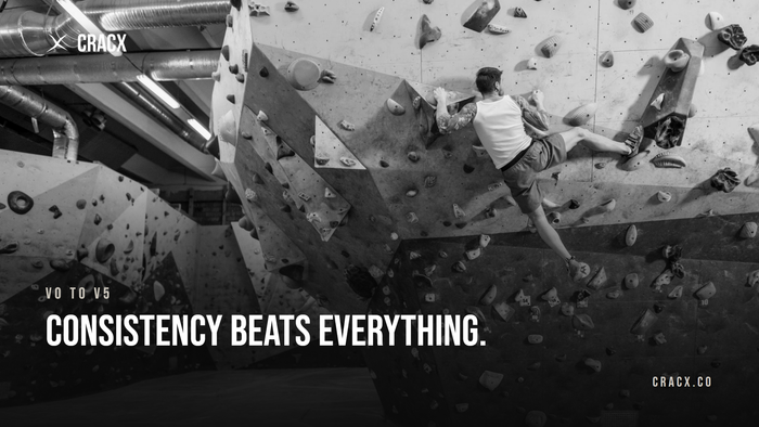 A boulderer high on a steep gym wall covered in holds and volumes