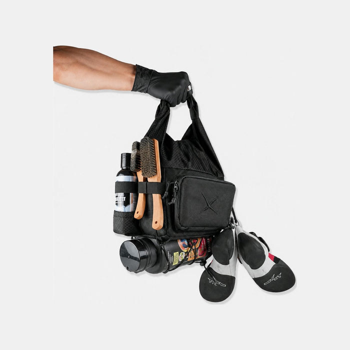 Bouldering chalk bucket loaded with climbing shoes, brush and chalk — a boulder bag that carries a whole session