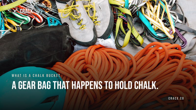A flat lay of climbing gear: shoes, rope, quickdraws, a helmet and a mesh stuff sack