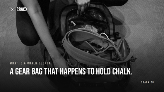 Hands opening a climbing gear bag with a harness and slings inside, on a gym floor
