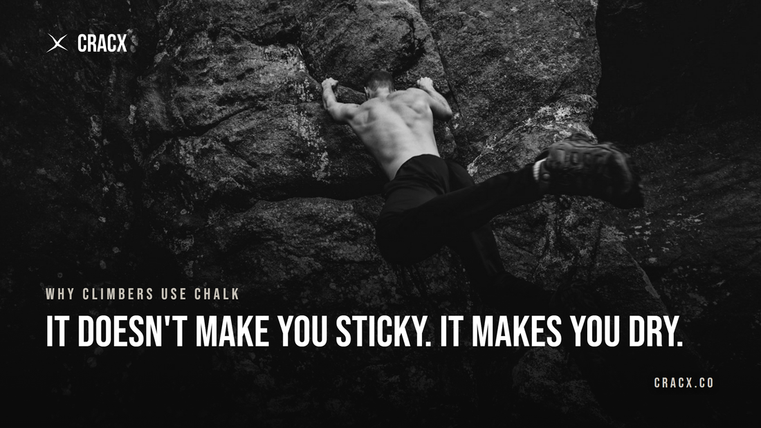 A climber pulling on rock above water, hands the only point of contact