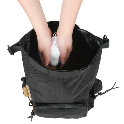 Both hands inside the open CRACX Ascend chalk bucket holding a chalk ball, showing the width of the main opening