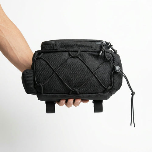 Underside of the CRACX Ascend resting on one hand, with the crisscross bungee cord, its cord lock and the reinforced base