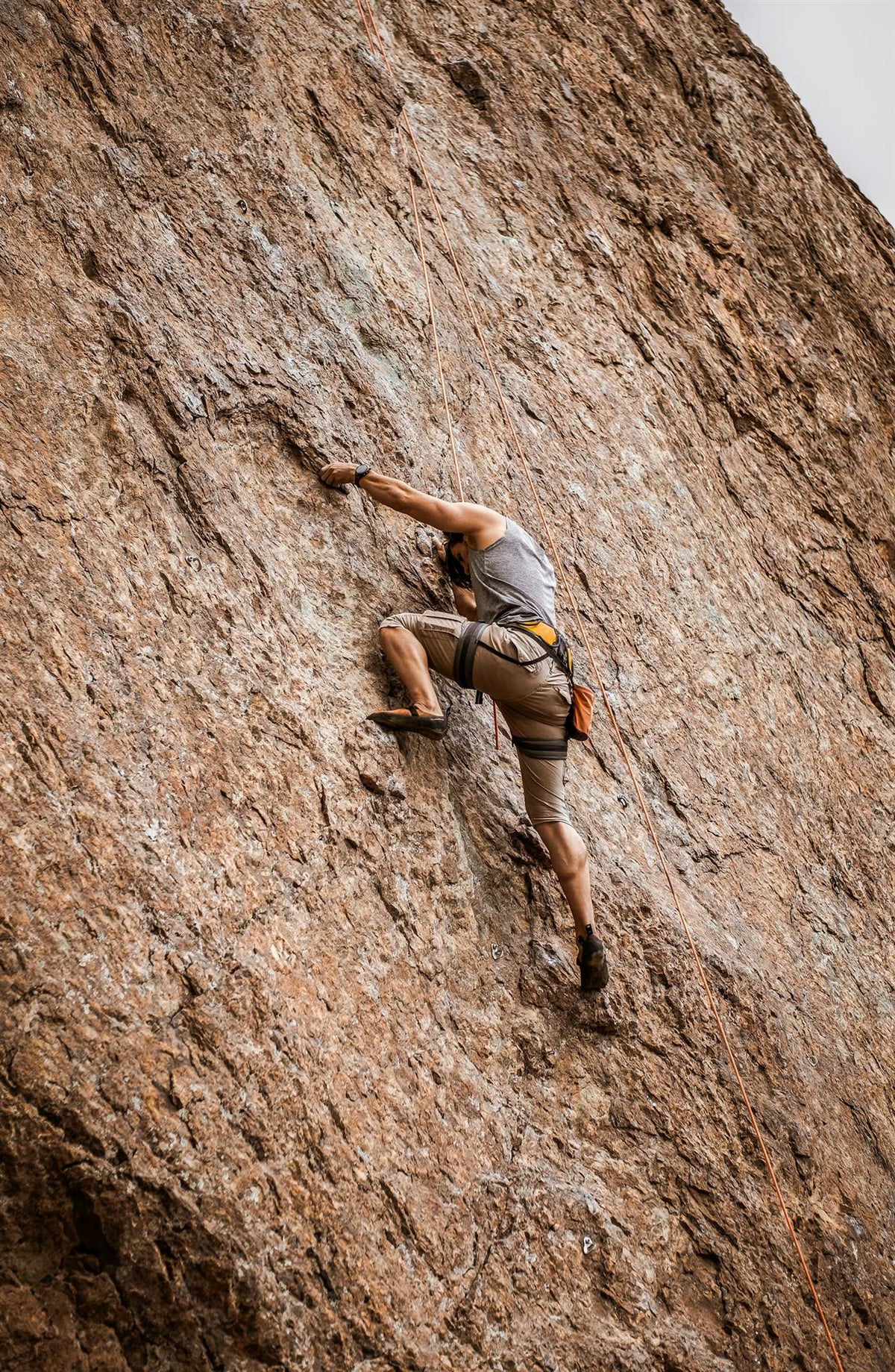 Climber clapping white chalk into the air