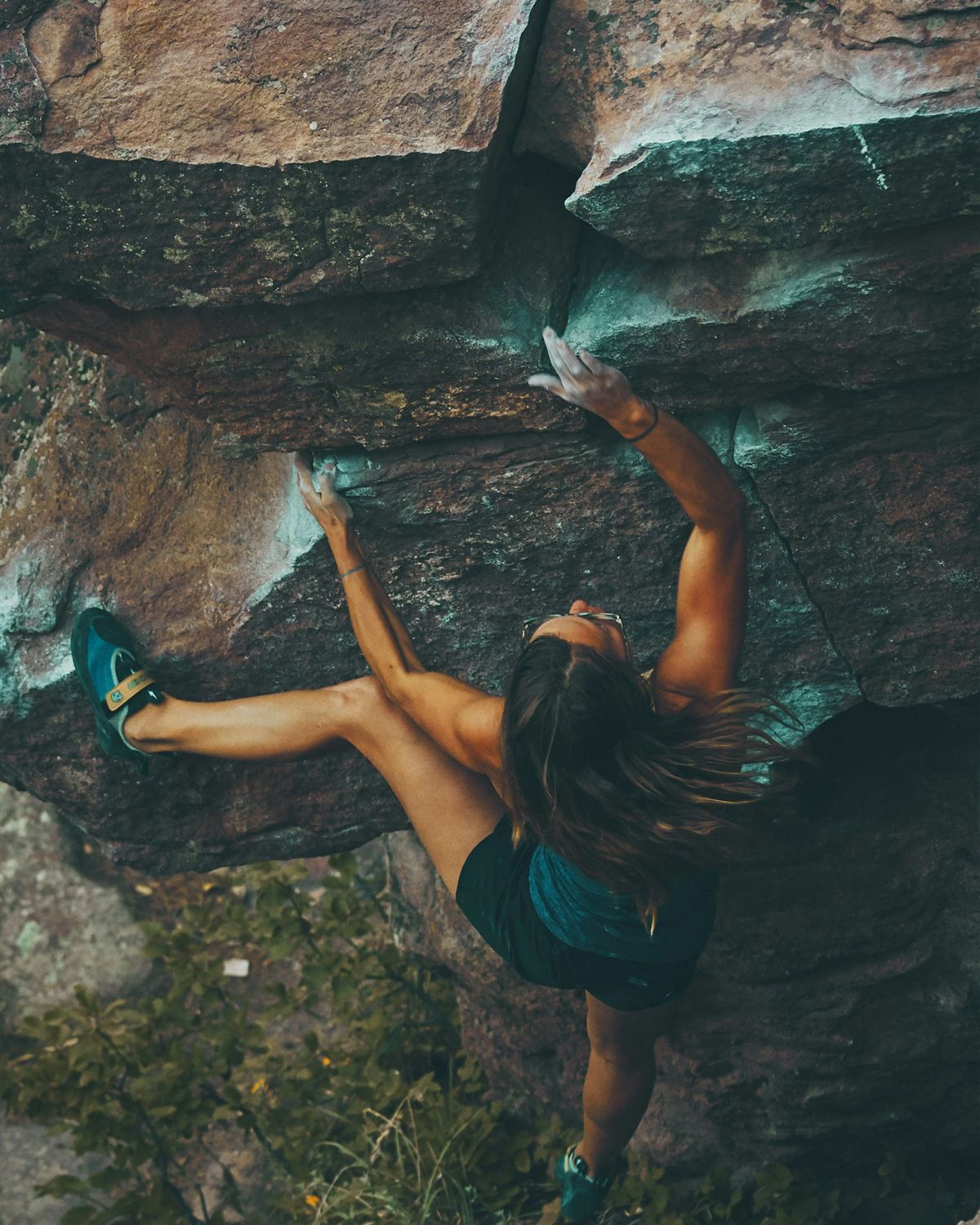 A boulderer working a move on overhanging rock, alone with the problem